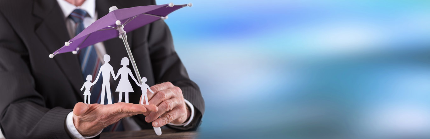 Man in suit holding umbrella over paper family